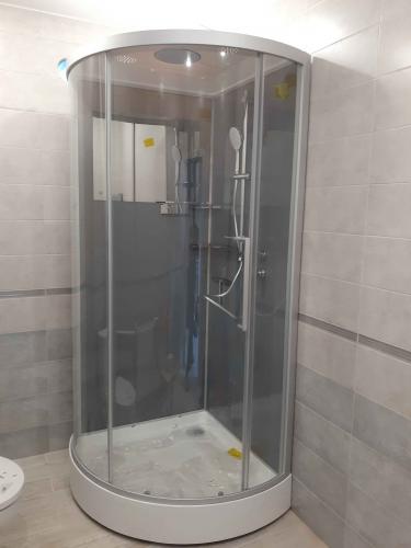 Установлена стеклянная кабина с герметичными дверцами, подключены смеситель и лейка, закреплён поддон, проверена герметичность соединений, завершены отделочные работы, обеспечена функциональность.
