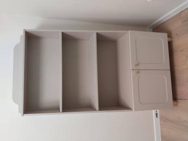 Собран новый стеллаж: установлены полки, закреплены дверцы, прикручены ножки. Готовая конструкция стоит ровно, элементы соединены прочно, поверхность чистая, без дефектов.