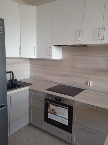 Установлены шкафы, закреплена столешница, подключена варочная панель, смонтирована мойка, установлены фасады, прикреплены ручки, подключена бытовая техника, завершена отделка.