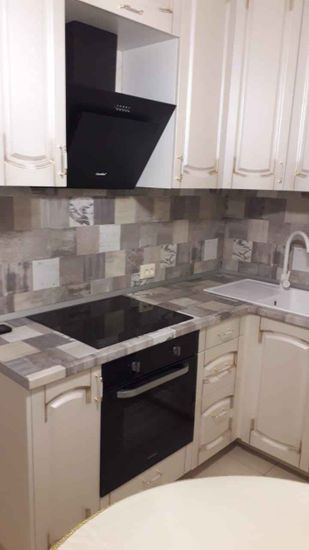 Установлены шкафы, смонтирована столешница, подключена варочная панель и духовой шкаф, закреплена вытяжка, установлена мойка и смеситель, выполнена облицовка фартука.