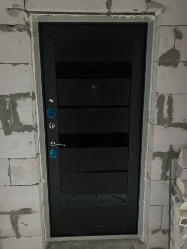 Установлена металлическая дверь, закреплена в проеме, отрегулированы петли, проверена работа замков, зазоры устранены, монтажная пена нанесена по периметру для герметичности.