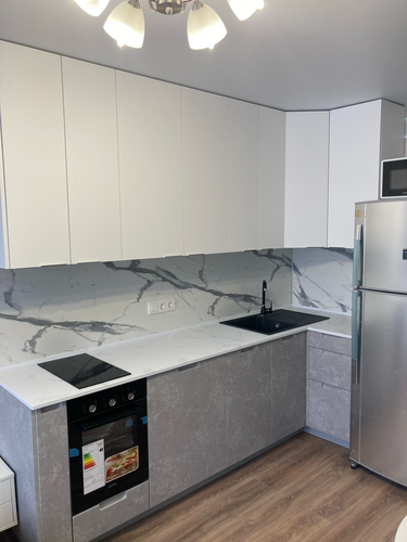 Установлена белая столешница из искусственного камня, идеально подогнанная по размерам, с вырезами для варочной панели и мойки, обеспечивающая современный и стильный вид кухни.