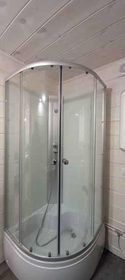 Установлена современная душевая кабина с прозрачными стенками и металлическим каркасом, подключены водопроводные коммуникации, обеспечена герметичность и функциональность конструкции.