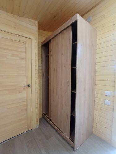 Собран шкаф с раздвижными дверями, установлены полки, закреплены направляющие, прикреплены ручки, проверена устойчивость конструкции, выполнена регулировка элементов для плавного открывания.