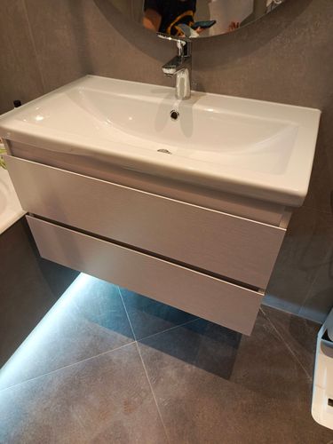 Установлена раковина с тумбой и смесителем, подключены водопроводные и сливные трубы, проверена герметичность соединений, выполнена регулировка высоты и уровня, обеспечена устойчивость конструкции.