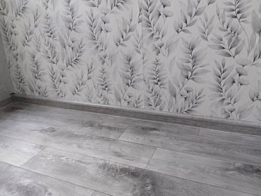 На ровное основание уложено новое покрытие, плотно прилегающее к стенам. Установлены плинтусы, создающие аккуратный и завершенный вид.