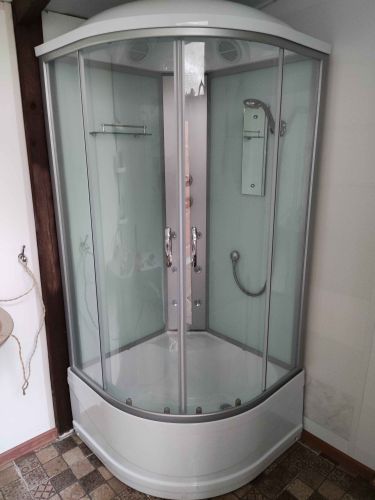 Установлена современная душевая кабина: закреплены стенки, поддон, двери, подключены водопровод и слив, проверена герметичность, отрегулированы элементы, завершена отделка.