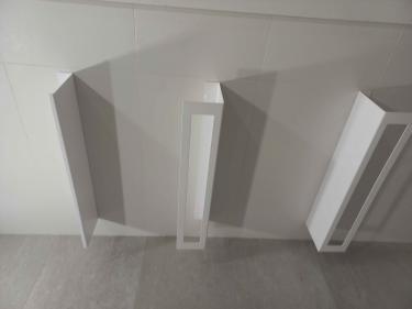 Три белые полки установлены на стене. Каждая надежно закреплена, ровно расположена, готова к использованию. Поверхность чистая, без видимых дефектов, крепеж скрыт.