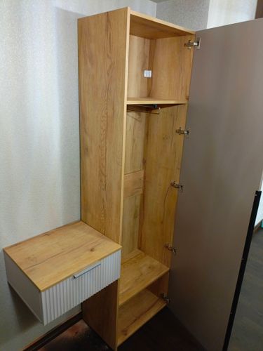 Собрана мебель: установлены полки, прикреплены дверцы, закреплены петли, собран ящик. Все элементы соединены, конструкция устойчива, готова к использованию.