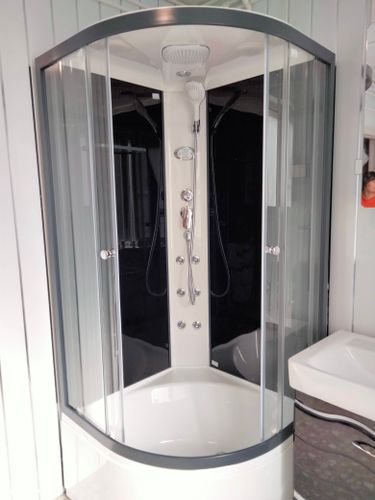 Установлена современная душевая конструкция с низким основанием. Смонтированы стеклянные панели, закреплены дверцы, подключены водопроводные коммуникации, проверена герметичность соединений.