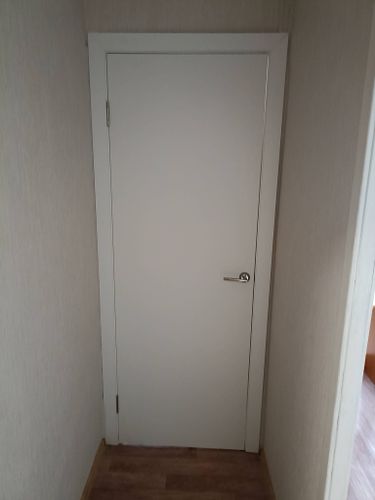 Установлен дверной блок: закреплена рама, навешено полотно, врезаны петли, ручка, замок. Проверена плавность открывания, закрытия. Завершена отделка откосов, зазоры устранены.