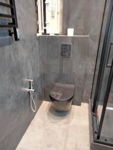 Закреплено сантехническое оборудование на стене, подключены коммуникации, установлена кнопка смыва. Проведены работы по герметизации и проверке на утечки. Завершена облицовка плиткой.