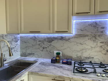 Установлена новая мраморная поверхность, заменены старые элементы, обновлён кухонный интерьер, добавлена светодиодная подсветка для улучшения освещения, обеспечена современная эстетика.