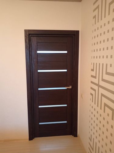 Изображена установленная дверь-гармошка. Проведены работы по монтажу, закреплению направляющих, сборке створок и проверке функциональности. Обеспечена плавная работа механизма.