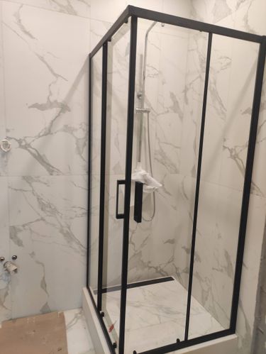 Установлена кабина с низким поддоном: закреплены стеклянные панели, смонтированы двери, подключен смеситель, герметизированы стыки, проверена герметичность соединений.