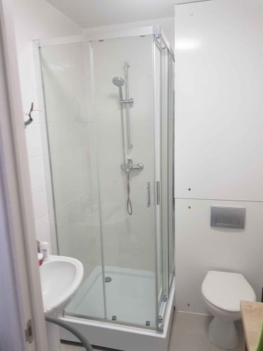 Установлена стеклянная кабина с раздвижными дверцами, смонтирован поддон, подключены водопроводные коммуникации, закреплены панели, проверена герметичность соединений.