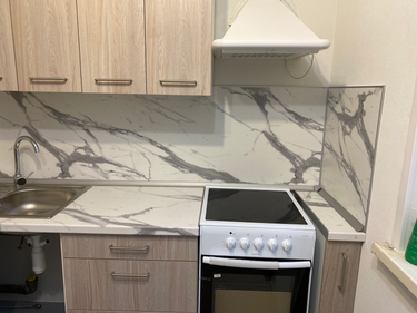 Установлены шкафы, закреплены фасады, смонтирована столешница, врезана мойка, подключен смеситель, установлена варочная панель, закреплена вытяжка, оформлен фартук из декоративного материала.