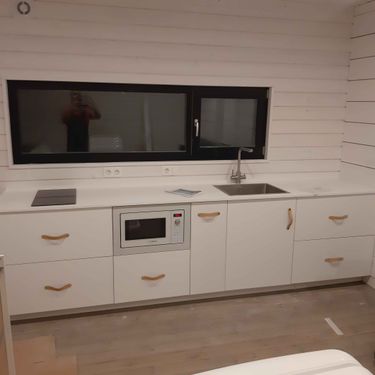 Гармонично установлена поверхность из композита, вырезаны отверстия под раковину и плиту, все элементы подогнаны, стыки аккуратно заделаны, обеспечена надежная фиксация.