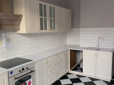 Готовая поверхность из камня установлена, вырезаны отверстия для мойки и варочной панели, все элементы подогнаны, швы аккуратно заделаны, обеспечена надежная фиксация.