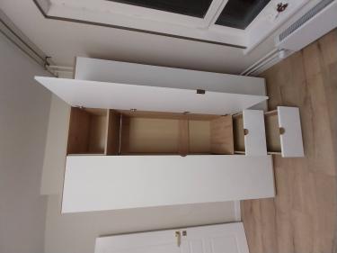 Собран шкаф с полками, выдвижными ящиками и дверцами. Установлены крепления, обеспечивающие устойчивость конструкции. Все элементы подогнаны точно, обеспечивая функциональность и эстетичность.