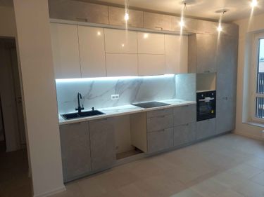 Установлены шкафы, смонтирована столешница, встроена техника, подключена мойка, закреплены фасады, выполнена подсветка, установлены розетки, завершена отделка стен.