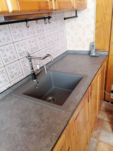 Установлена новая столешница из ДСП, врезана мойка, подключен смеситель. Все элементы аккуратно подогнаны, обеспечена надежная фиксация. Поверхность чистая, без видимых дефектов.