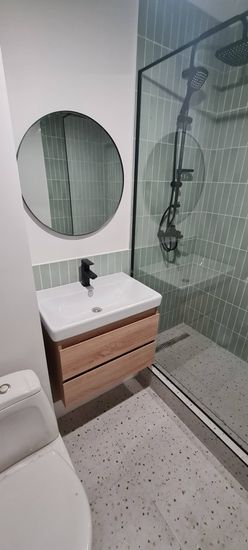 Установлено круглое зеркало в ванной комнате над раковиной. Закреплено надежно, ровно, с учетом дизайна интерьера. Завершено аккуратно, без повреждений поверхности стены.