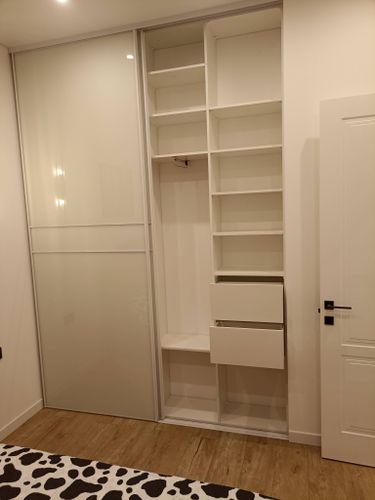 Собран шкаф с раздвижными дверями, установлены полки, ящики, вешалка. Все элементы надежно закреплены, конструкция выровнена, двери плавно скользят. Завершено оформление внутреннего пространства.