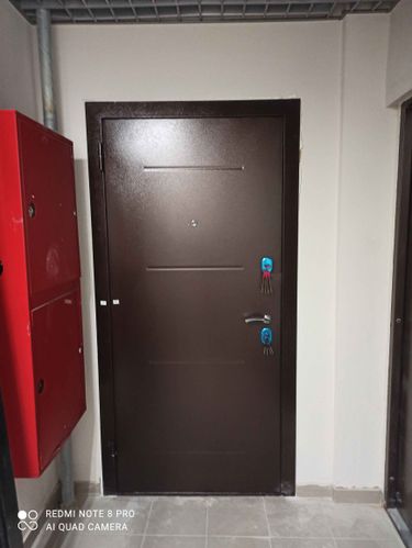 Дверь обновлена с помощью МДФ панелей, которые установлены на поверхность, улучшая внешний вид и добавляя теплоизоляцию. Работа завершена аккуратно, без видимых дефектов.