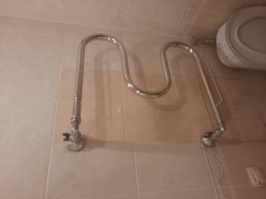 Установлен водяной полотенцесушитель, подключены трубы, закреплены крепления на стене, проверена герметичность соединений, проверена работа устройства, завершена отделка вокруг.