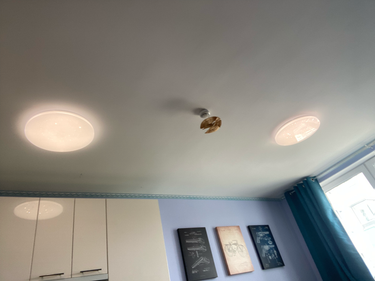 Установлены два круглых светильника на потолке, обеспечивающие равномерное освещение. Проведены работы по подключению к электросети, проверена исправность и надежность крепления.