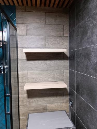 Установлены две деревянные полки на стене с плиткой. Полки ровно закреплены, обеспечивая устойчивость и функциональность. Пространство между полками позволяет разместить различные предметы.