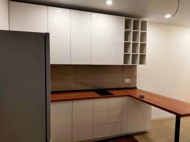 Установлены шкафы, закреплены фасады, смонтирована столешница, подключены розетки, размещены полки, установлена варочная панель, выполнена подгонка элементов, обеспечена функциональность.