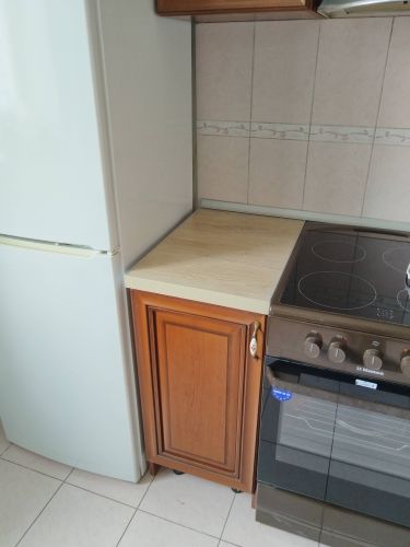 На кухне установлена ДСП столешница, аккуратно подогнанная к стенам и мебели. Все стыки герметично заделаны, поверхность ровная и гладкая, обеспечивая функциональность и эстетичный вид.