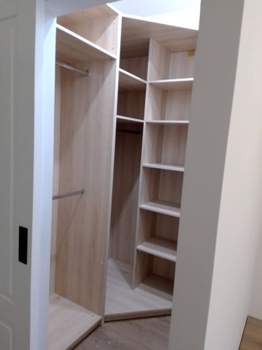 Установлены полки в угловом шкафу, обеспечивающие оптимальное использование пространства. Конструкция надежно закреплена, все элементы выровнены и готовы к эксплуатации.