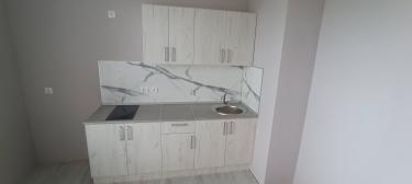 Установлены шкафы, закреплены фасады, смонтирована столешница, подключена мойка, установлена варочная панель, проведены коммуникации, выполнена отделка стен панелями.