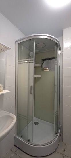 Установлена новая душевая конструкция с низким поддоном. Смонтированы стеклянные двери, закреплены полки и подключены водопроводные коммуникации. Завершена герметизация швов.