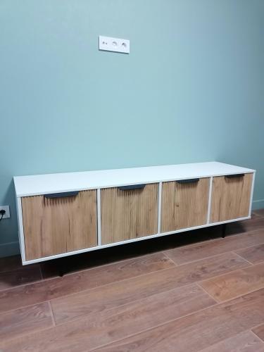 Собрано изделие с четырьмя дверцами, установлено на ножки. Все элементы соединены, конструкция устойчива, поверхности ровные, фасады выровнены, ручки прикреплены.