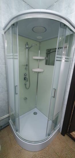 Установлена кабина: смонтированы стены, поддон, двери. Подключены смеситель, лейка, полки. Проверена герметичность, функциональность. Завершены работы по подключению к водопроводу, канализации.