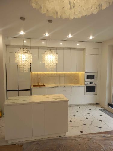 Установлены шкафы, смонтирована столешница, подключены бытовые приборы, закреплены светильники, выполнена отделка стен и пола, установлена раковина, подключены коммуникации.