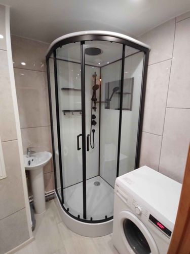 Выполнен монтаж душевой кабины: установлены стеклянные панели, поддон, смеситель и дверцы. Подключены водопровод и слив, проверена герметичность, отрегулированы элементы.