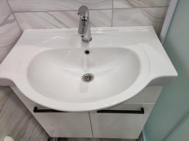 Установлен умывальник с подключением труб горячего и холодного водоснабжения, смонтирован смеситель, обеспечена герметичность соединений, выполнена проверка на утечки, всё функционирует корректно.