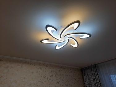 Установлена современная светодиодная люстра на потолке, подключены провода, проверена работа освещения, закреплено крепление, обеспечена надежность конструкции, завершен монтаж.