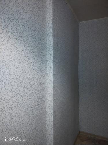 Стены покрыты обоями с мелким узором, аккуратно совмещены стыки, поверхность ровная, без видимых дефектов. Углы обработаны тщательно, создавая завершенный вид.