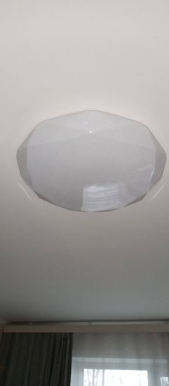 Установлен новый светильник на потолок, подключены провода, закреплено крепление, проверена работа устройства. Светильник надежно зафиксирован, обеспечивая равномерное освещение помещения.