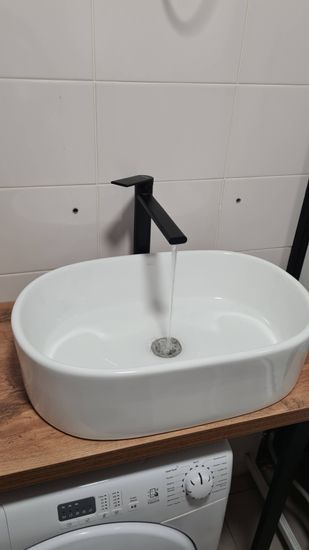 На стену закреплен электрический полотенцесушитель, подключен к сети, проверена работоспособность, обеспечена безопасность, скрыты провода, устройство готово к использованию.