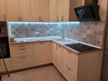 Установлены шкафы, закреплены фасады, смонтирована столешница, подключена варочная панель, врезана мойка, размещены ручки, выполнена подводка освещения, оформлен фартук.