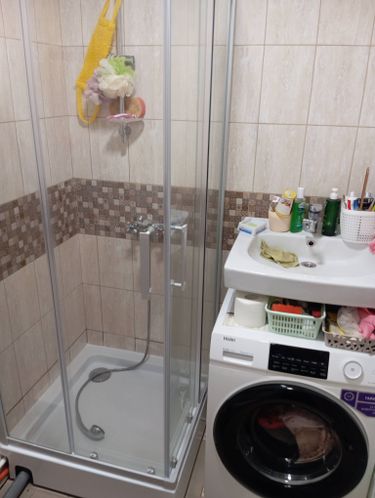 Установлен низкий поддон, закреплены стеклянные панели, подключены смеситель и душевой шланг. Все элементы герметично зафиксированы, обеспечена надежная изоляция и функциональность.