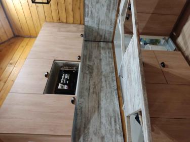 Установлена новая столешница на кухне. Обновлённая поверхность гармонично сочетается с интерьером, обеспечивая функциональность и эстетичность. Работа завершена, все элементы на месте.