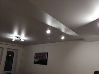 На потолке закреплены светильники, подключены к электропитанию, проверена работоспособность. Установлены в нужных местах, обеспечивая равномерное освещение в комнате.